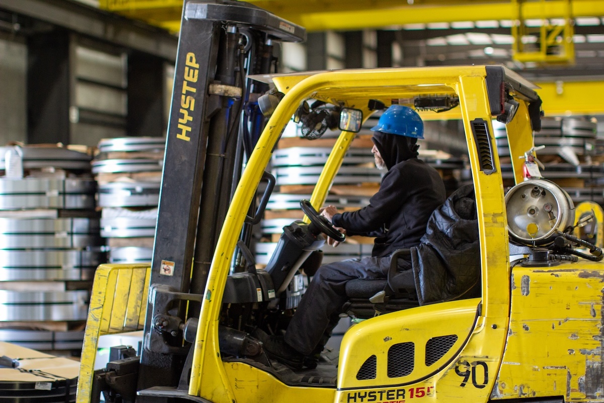 Rockwell Hardness Testing of Steel Parts | Quality Control Process Technician performing Rockwell hardness test on steel sample using Clark B-Scale machine, with digital hardness reading displayed.