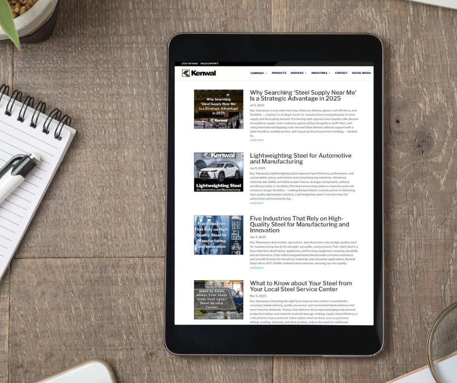 Tablet displaying Kenwal Steel’s blog page with articles about automotive steel, manufacturing innovations, and local steel supply advantages, placed on a wooden table with notepad and pen.